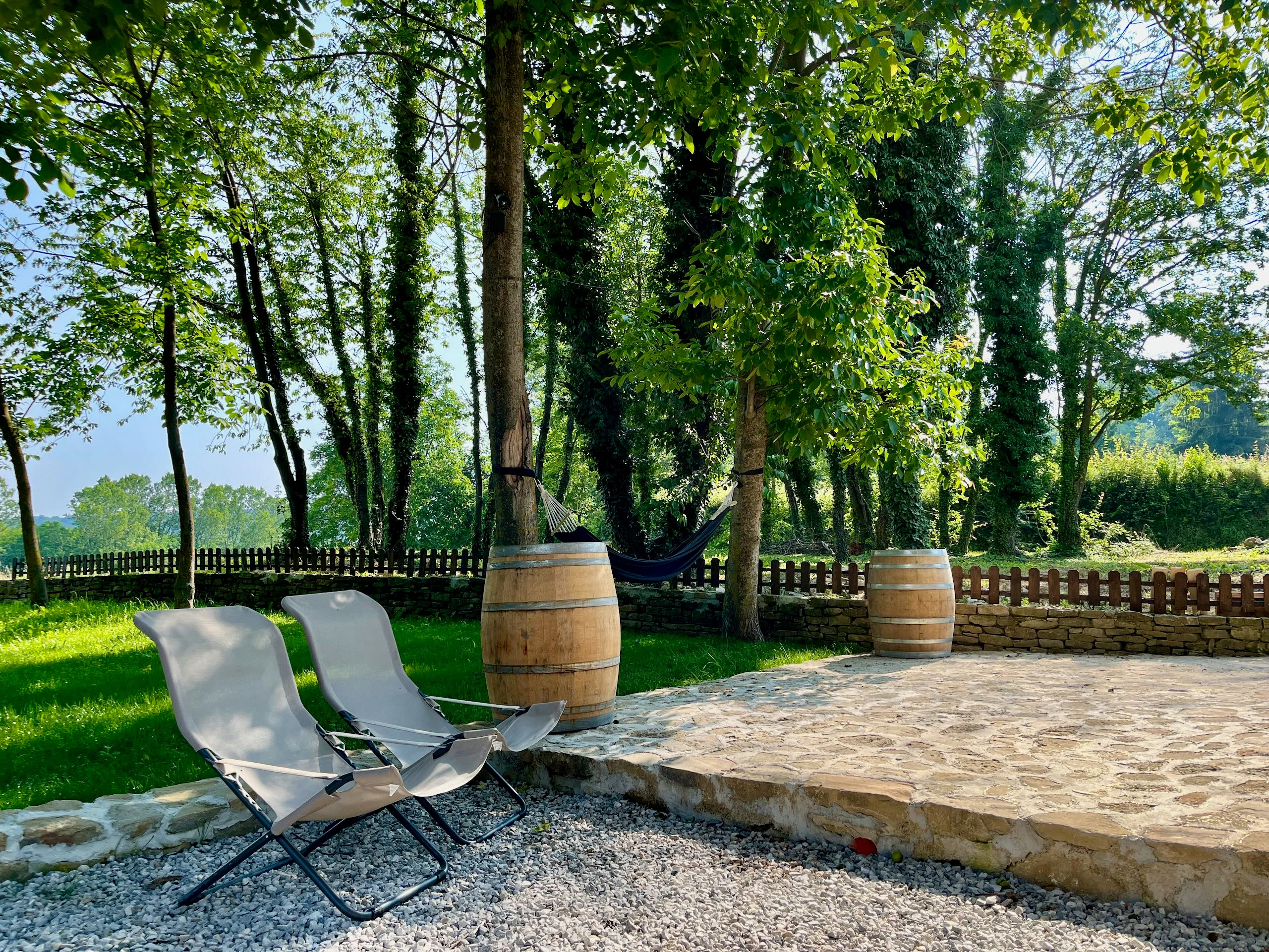 Liegestühle auf der Terrasse mit Weinfässern und Hängematte